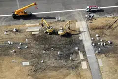 Officials remove the wreckage of burnt Japan Airlines' (JAL) Airbus A350 after a collision with a Japan Coast Guard aircraft at Haneda international airport in Tokyo, Japan, Jan 7, 2024.
