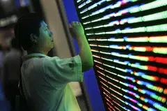 A visitor inspects an energy-efficient LED panel's construction at the LED (Light-Emitting Diodes) exhibition in Taipei, Taiwan. 