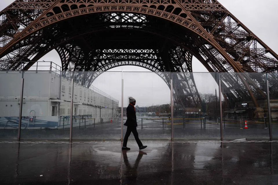 A pedestrian walks past the Eiffel Tower, which is closed to the public on the fourth day of its staff's strike in Paris, France, Feb 22, 2024. 