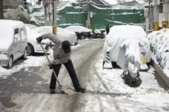 A man shovels snow on a street in Beijing, China, Dec 11 2023. 