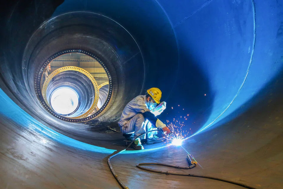 An employee working on a wind turbine tower at a factory in Lianyungang; China has installed 365 gigawatts (GW) of wind power capacity and 392 GW of solar capacity by the end of last year, about a third of the world’s total.