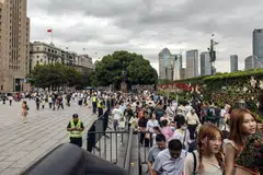 Pedestrians along the Bund in Shanghai, China on Oct 3, 2023. Chinese are splashing their cash on dining out and travel.