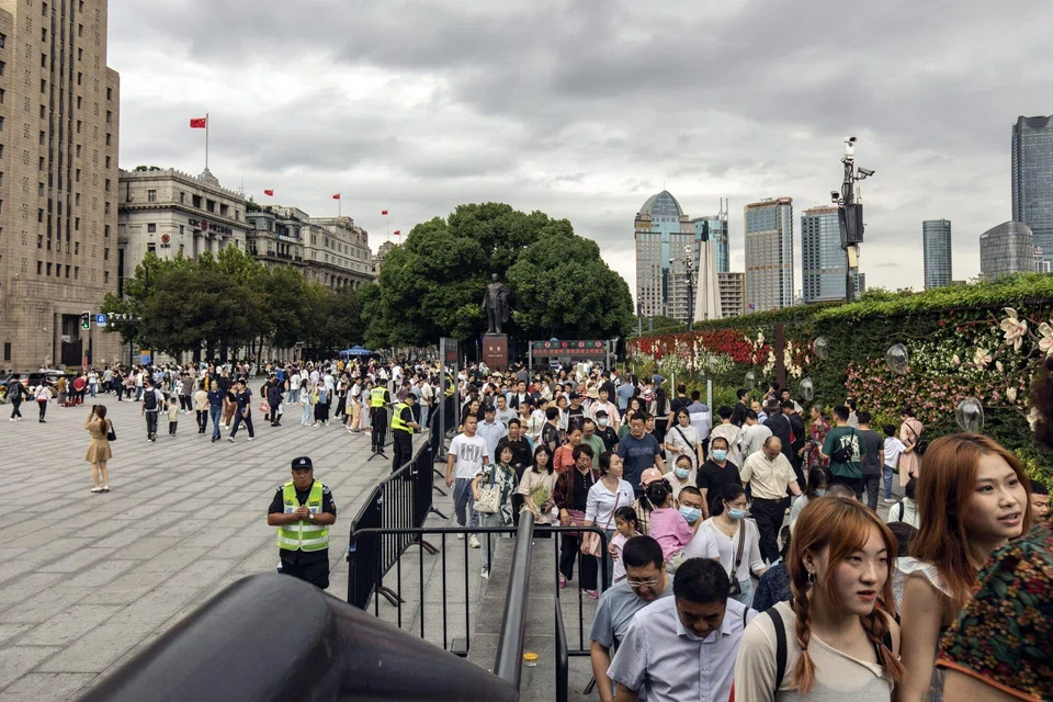 Pedestrians along the Bund in Shanghai, China on Oct 3, 2023. Chinese are splashing their cash on dining out and travel.