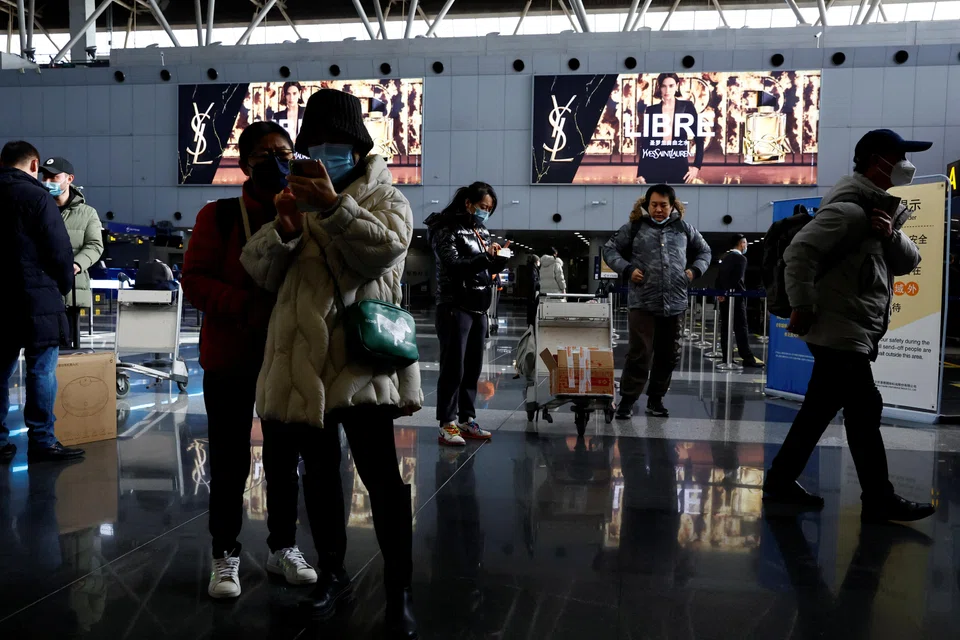 Travellers at Beijing Capital International Airport in Beijing, China, Dec 27, 2022. Online searches for flights abroad surged after Beijing said it would scrap mandatory quarantine for overseas arrivals, state media reported.