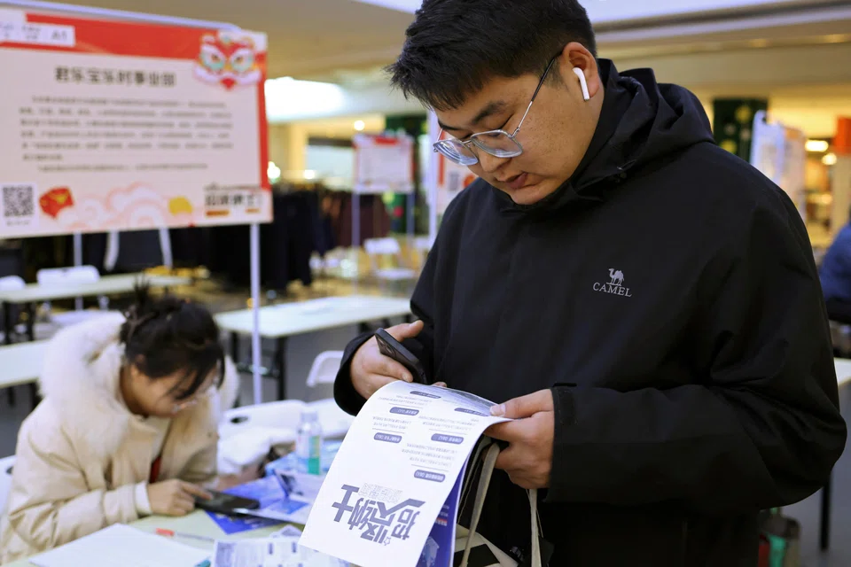 Zhang Baichuan, 23, checks a job advertisement at a job fair in Shijiazhuang, Hebei province.