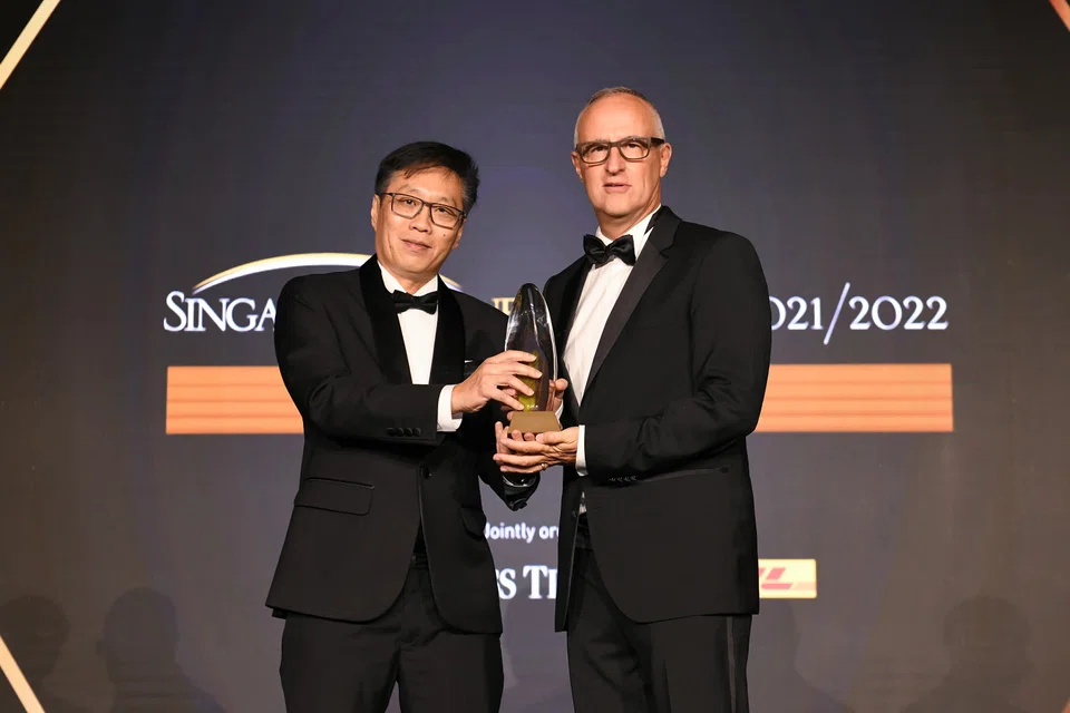 Wong Wei Kong (left) editor of The Business Times, presenting The Enterprise Award to Laurent Junique, founder and CEO of TDCX. 