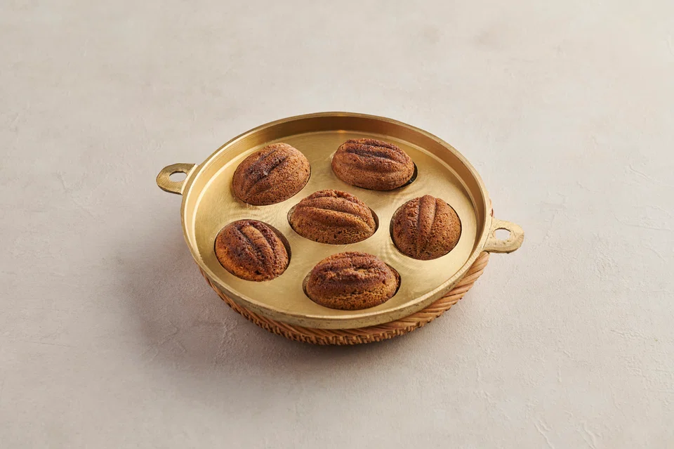 Brown sugar kuih bahulu are made in traditional brass moulds.
