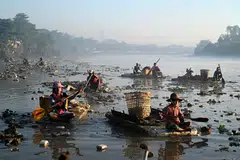Waste collectors on polystyrene boats look for plastic and glass to recycle in Yangon's Pazundaung Creek. Dozens have taken to the creek's murky waters after being driven to find work by a post-coup economic crisis. 