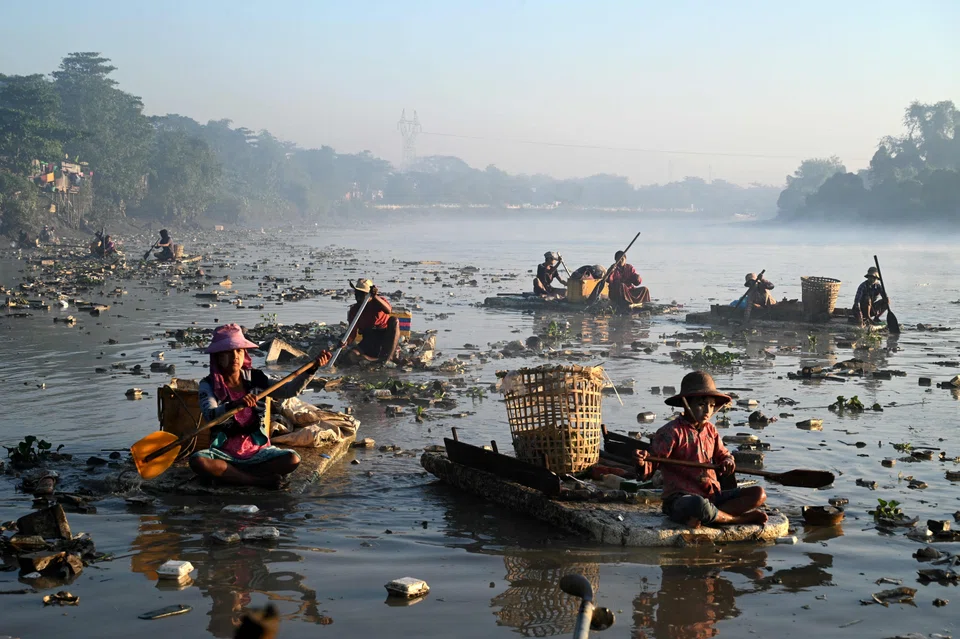 Waste collectors on polystyrene boats look for plastic and glass to recycle in Yangon's Pazundaung Creek. Dozens have taken to the creek's murky waters after being driven to find work by a post-coup economic crisis. 