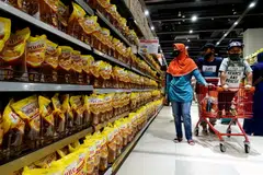 People shop for cooking oil made from oil palms at a supermarket in Jakarta, Indonesia, Mar 27, 2022. Indrawati likened the current food supply situation to the early weeks of the Covid-19 pandemic, when countries competed with each other for masks, medical protective gear and other critical supplies.