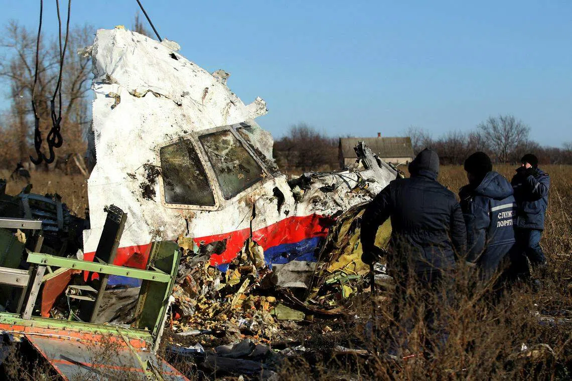 Local workers transport a piece of wreckage from Malaysia Airlines flight MH17 at the site of the plane crash near the village of Hrabove (Grabovo) in Donetsk region, eastern Ukraine on Nov 20, 2014. 