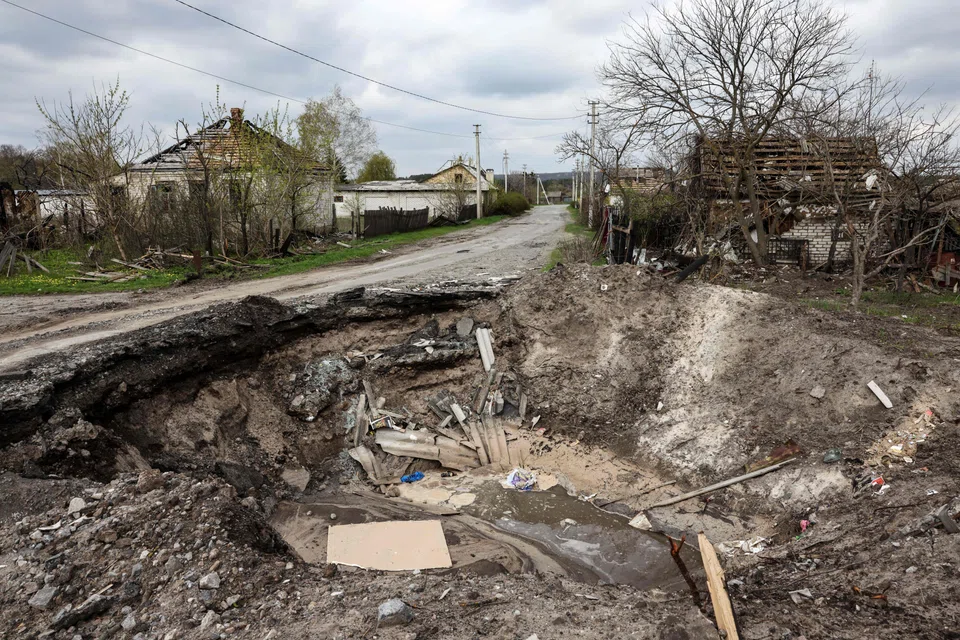 A crater and a destroyed home are pictured in the village of Yatskivka, eastern Ukraine on April 16, 2022. 