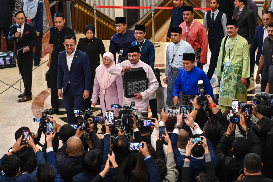 On Oct 13, Malaysia’s Prime Minister and Finance Minister Anwar Ibrahim showing a briefcase containing his 2024 national budget speech at the Malaysian Parliament in Kuala Lumpur. 