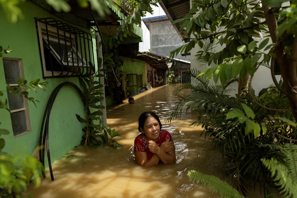 A woman wades through chest-deep flood after Super Typhoon Noru, in San Ildefonso, Bulacan province, Philippines, on Sep 26, 2022. 