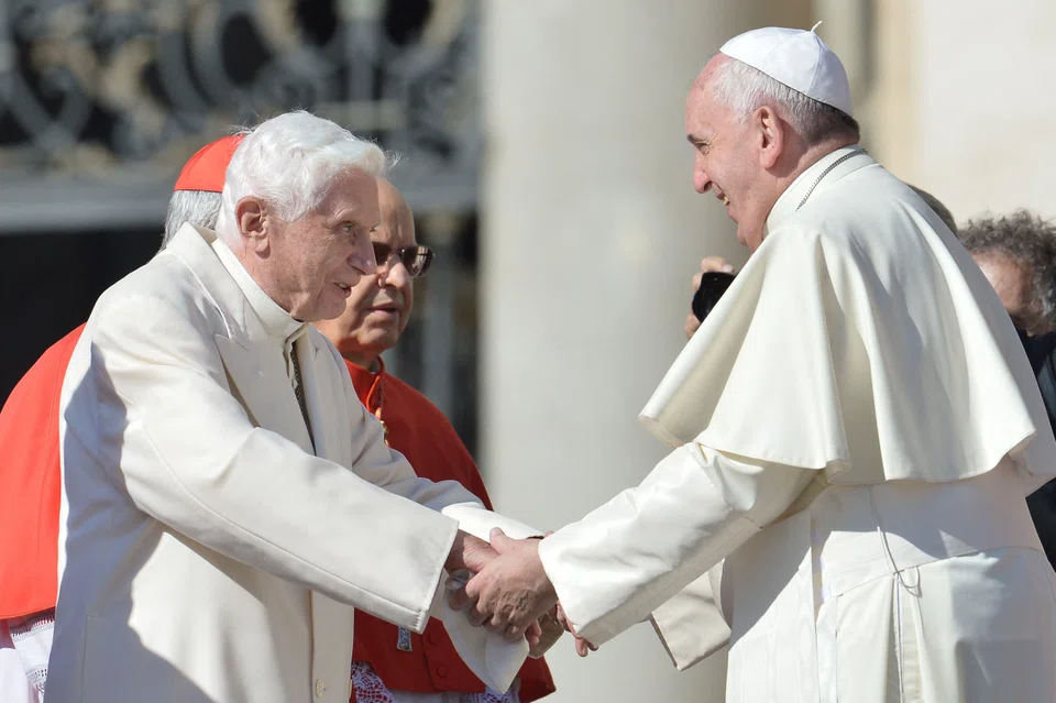 Former Pope Benedict XVI (left) speaking with Pope Francis at the Vatican in September 2014.