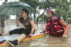 A woman being evacuated from a flooded area following heavy rains caused by Typhoon Haikui in Xiamen, in China's southern Fujian province. Economic losses have reached 5.05 billion yuan (S$942.7 million). 