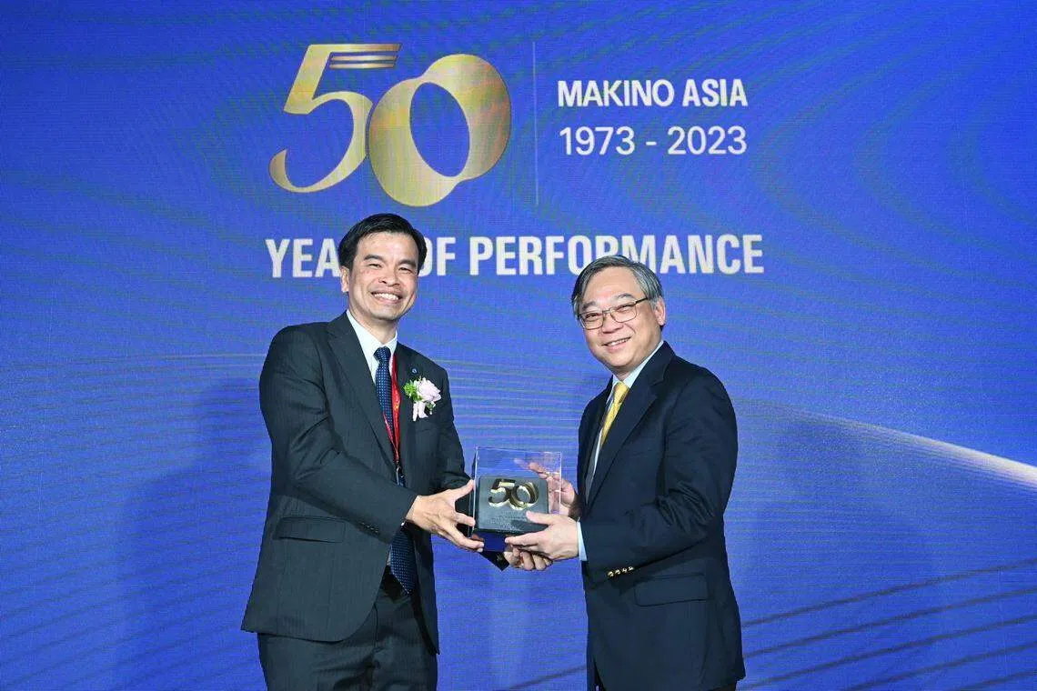 Makino Asia chief executive officer Neo Eng Chong presents a token of appreciation to Minister for Trade and Industry Gan Kim Yong at the company's golden jubilee celebration on Wednesday.