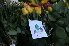 Flowers and a card depicting Queen Elizabeth II with Paddington Bear and a corgi at Holyrood House in Edinburgh, Scotland, Britain, Sept 10, 2022. 