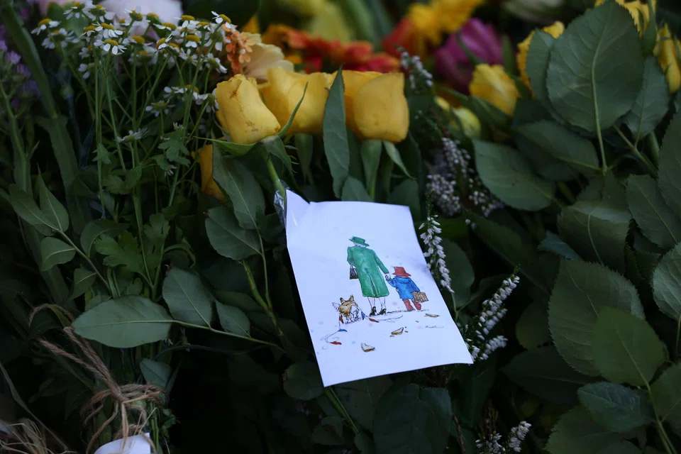 Flowers and a card depicting Queen Elizabeth II with Paddington Bear and a corgi at Holyrood House in Edinburgh, Scotland, Britain, Sept 10, 2022. 