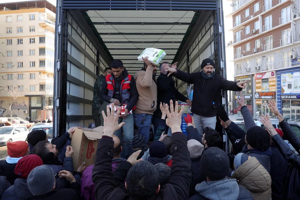 Food and grocery supplies distributed next to collapsed building in southeastern Turkey.