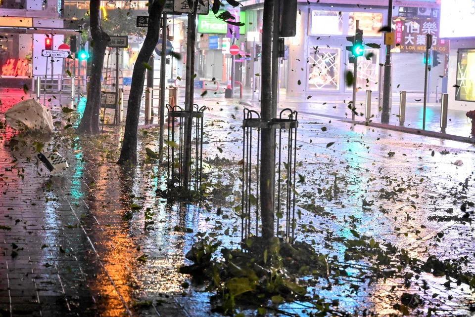 Debries caused by high winds brought by Super Typhoon Saola fly on a street in Causeway Bay in Hong Kong.