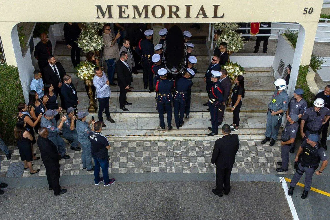 The coffin of the late Brazilian football star Pele arriving at the Santos' Memorial Cemetery after a funeral procession in Santos, Sao Paulo state, Brazil. His remains will be interred in a mausoleum contained within a vertical cemetery.