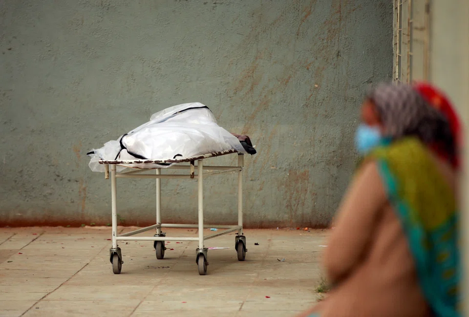 Relatives wait to receive the body of a man after he died from the coronavirus disease (Covid-19), outside a mortuary of a Covid-19 hospital in Ahmedabad, India, Feb 4, 2022.