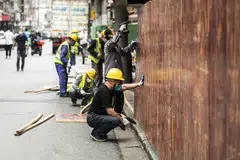 Workers removing barriers previously surrounding a neighbourhood placed under lockdown due to Covid-19 in Shanghai on Monday. China reported the fewest new Covid-19 cases in almost 3 months, with the easing of outbreaks in Shanghai emboldening the authorities to relax some of the strictest virus controls of the pandemic and move to stimulate the country’s faltering economy.  
