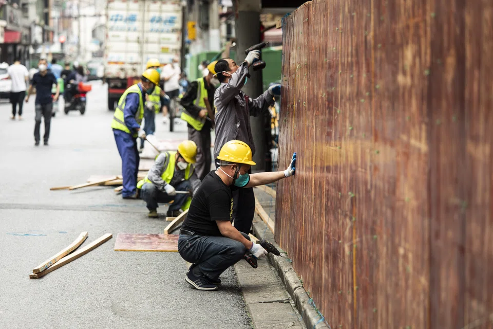 Workers removing barriers previously surrounding a neighbourhood placed under lockdown due to Covid-19 in Shanghai on Monday. China reported the fewest new Covid-19 cases in almost 3 months, with the easing of outbreaks in Shanghai emboldening the authorities to relax some of the strictest virus controls of the pandemic and move to stimulate the country’s faltering economy.  