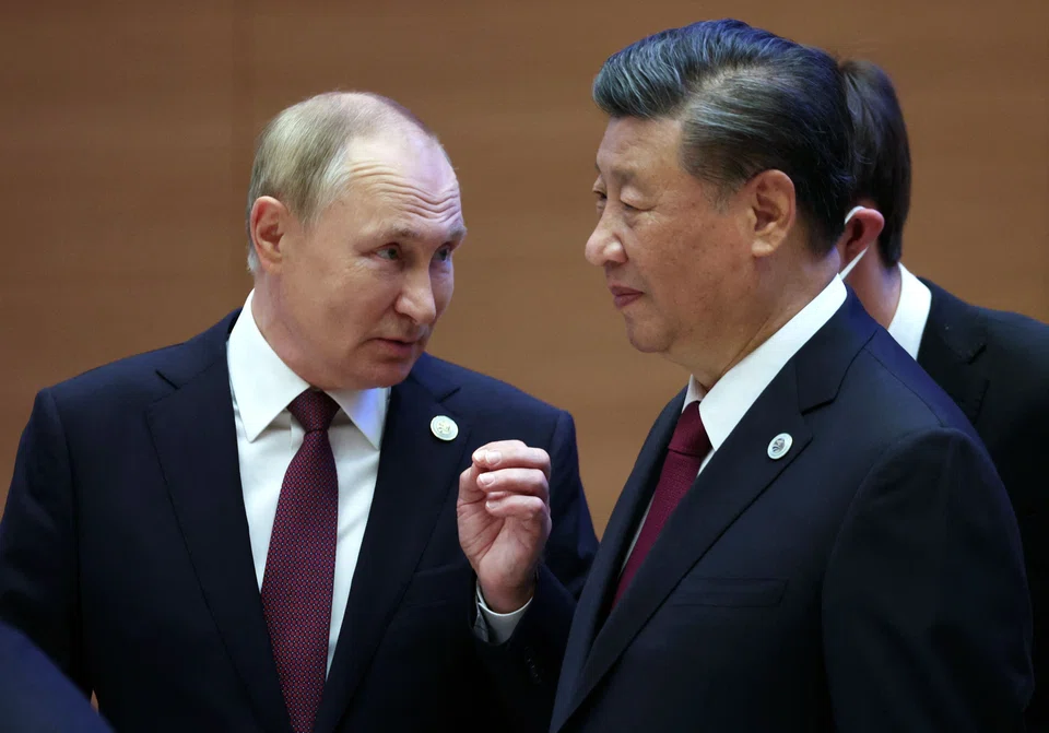 Russian President Vladimir Putin speaks to China's President Xi Jinping during the Shanghai Cooperation Organisation (SCO) leaders' summit in Samarkand on Sept 16, 2022. US President Biden said he told Xi that violating sanctions imposed by a coalition of countries would be a “gigantic mistake.” 