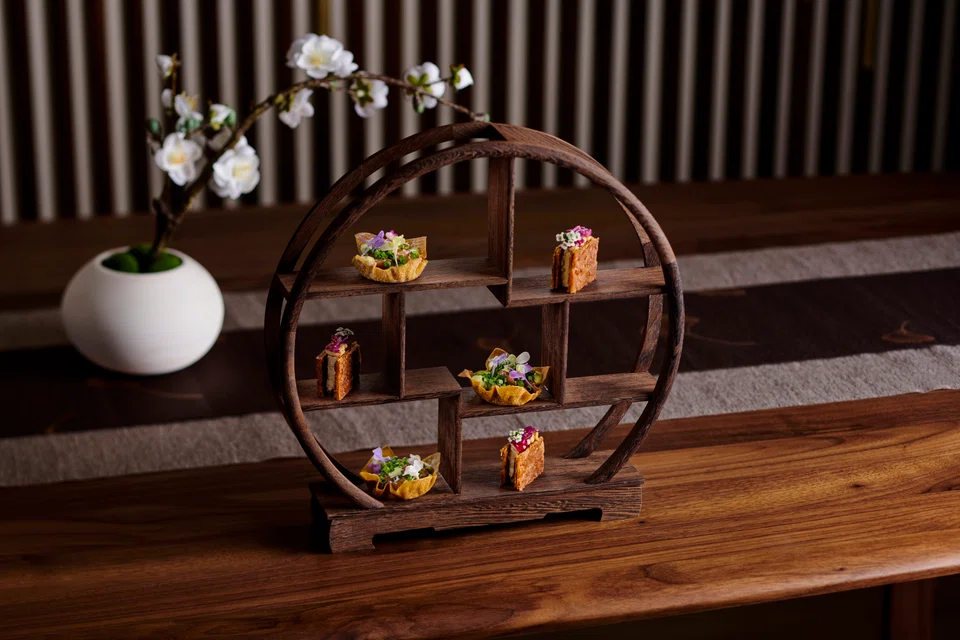 Snacks are presented on a pretty Chinese wooden frame.