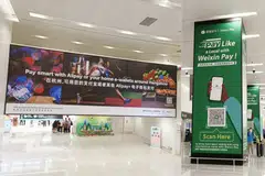 Banners promoting the payment apps of Ant and Tencent compete for tourists' attention at Hangzhou's international airport.