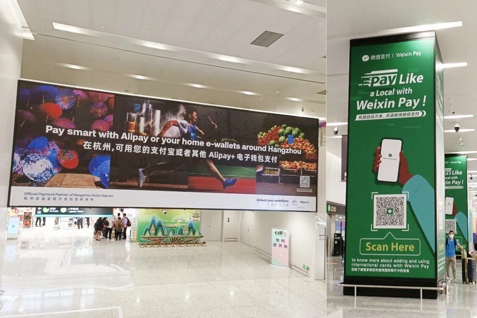 Banners promoting the payment apps of Ant and Tencent compete for tourists' attention at Hangzhou's international airport.