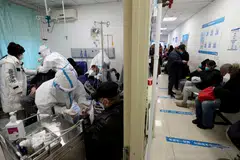 Medical workers in protective suits attend to patients in a hospital in Beijing, China, Dec 27, 2022.  
