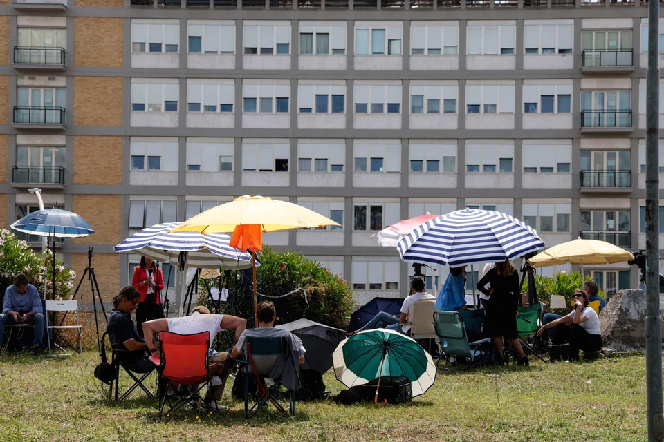 Journalists gather near the Agostino Gemelli University Hospital, where Pope Francis underwent his surgery. The pope is in good general condition, alert and breathing spontaneously, said the Vatican. 
