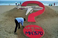 An Indian sand artist with his sand sculpture of the missing Malaysia Airlines flight MH370 on a beach in eastern India a year after the disappearance of the plane. The flight is now regarded as one of the world's greatest aviation mysteries, a decade on.