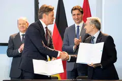 German Chancellor Olaf Scholz (left) and Canadian Prime Minister Justin Trudeau (right) watch as Volkswagen AG's CEO Herbert Diess (second left) shakes hands with Canadian Minister of Innovation, Science and Industry, Francois-Philippe Champagne at the Canadian-German Chamber of Industry and Commerce in Toronto, Canada, on Aug 23, 2022. 