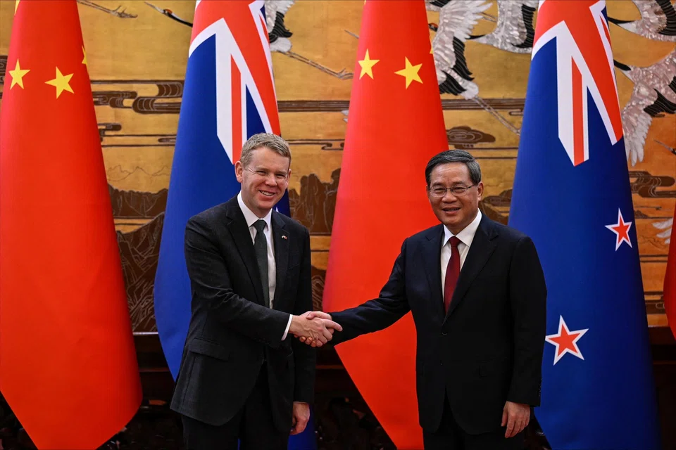 Chinese Premier Li Qiang and New Zealand Prime Minister Chris Hipkins shake hands during a signing ceremony at the Great Hall of the People in Beijing. 