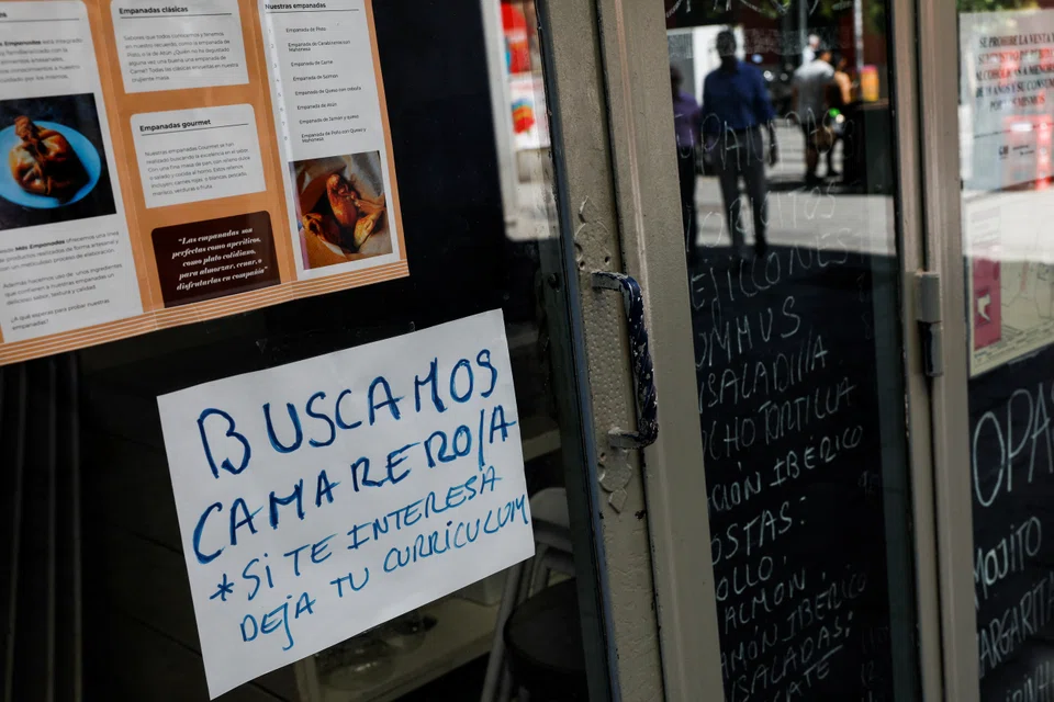 A sign that reads "Waiter needed. If interested, drop CV"  is posted on the window of a restaurant in central Madrid, Spain. Spain’s catering industry is 200,000 workers short, according to national hospitality associations.