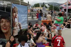 Fans wait in line outside Nilton Santos stadium for the Taylor Swift concert, following the death of a fan due to the heat during the first day concert.