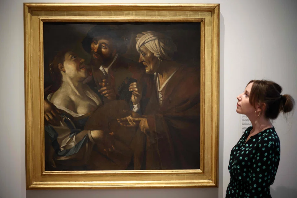 A gallery assistant studies a work by the Dutch forger Han van Meegeren, whose works often ended up in the hands of leading Nazis, including Hermann Goering. 