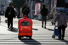 A DeliRo delivery robot moving along on a street outside Tokyo, part of an experiment businesses hope will tackle labour shortages and rural isolation. 