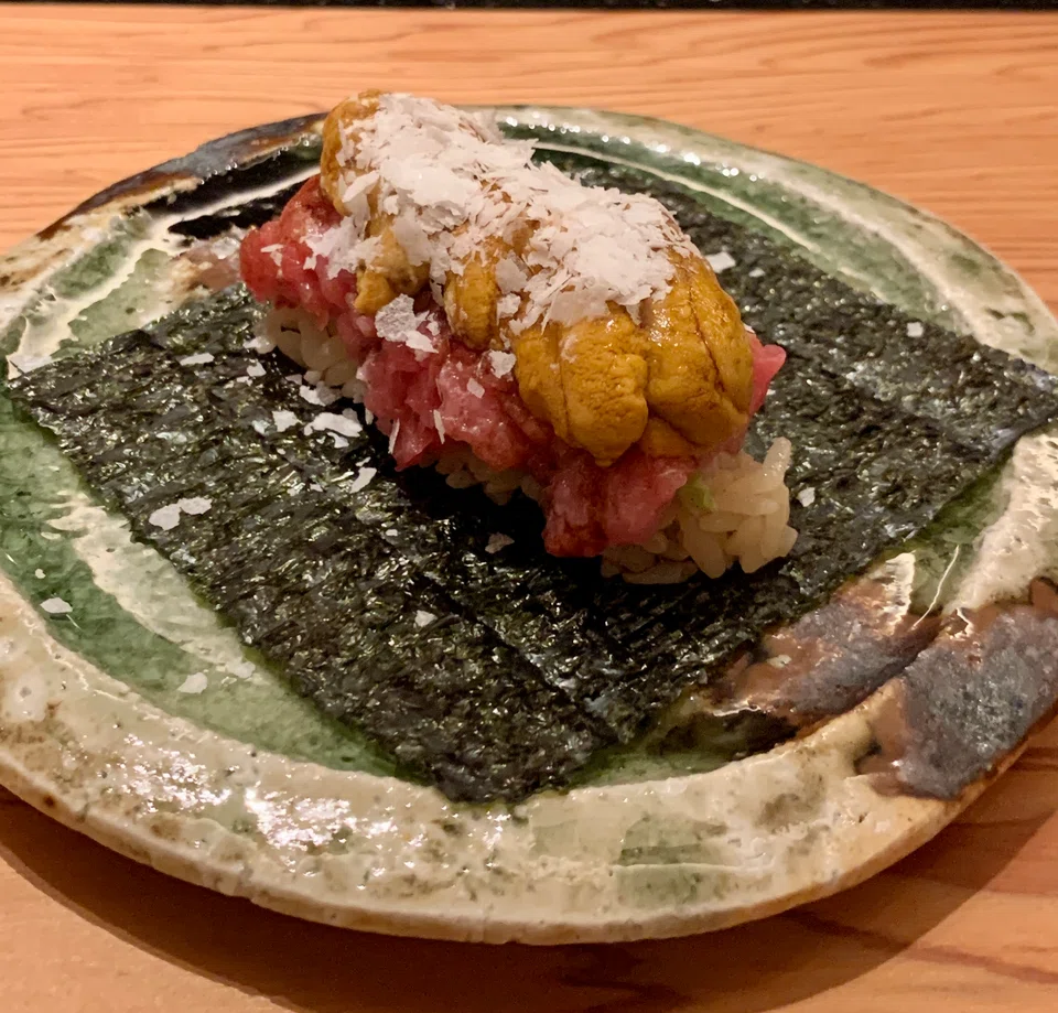 Handroll of nori seaweed layered with maguro and uni.