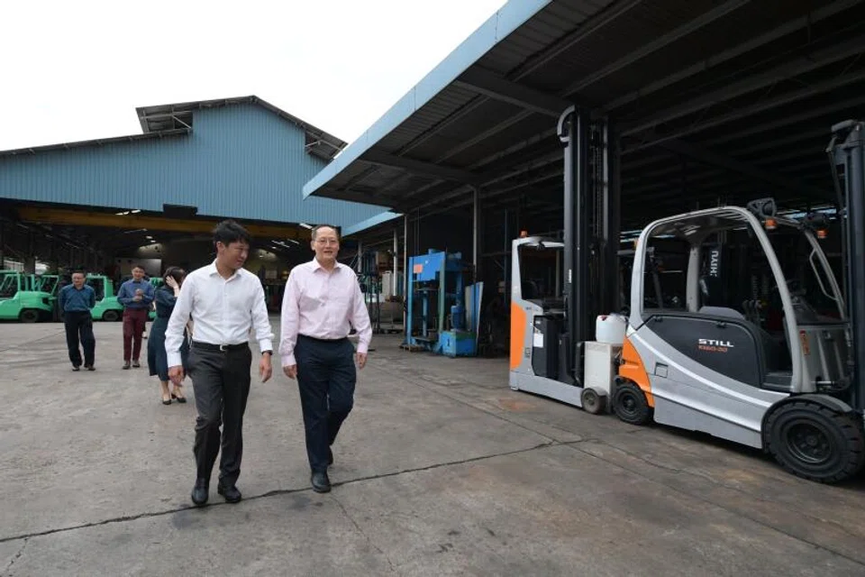 CEO of Goldbell Group Arthur Chua (in white) with Tan See Leng, Minister for Manpower and Second Minister for Trade and Industry at Goldbell's Benoi Road premise.