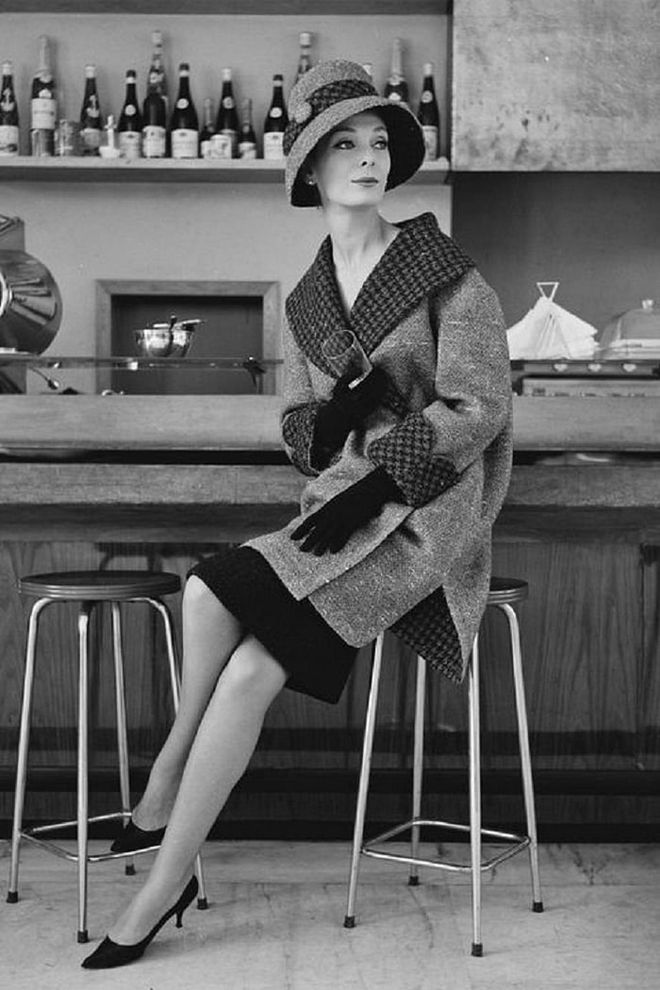 A woman modeling a winter coat with houndstooth trim and matching hat in Rome.