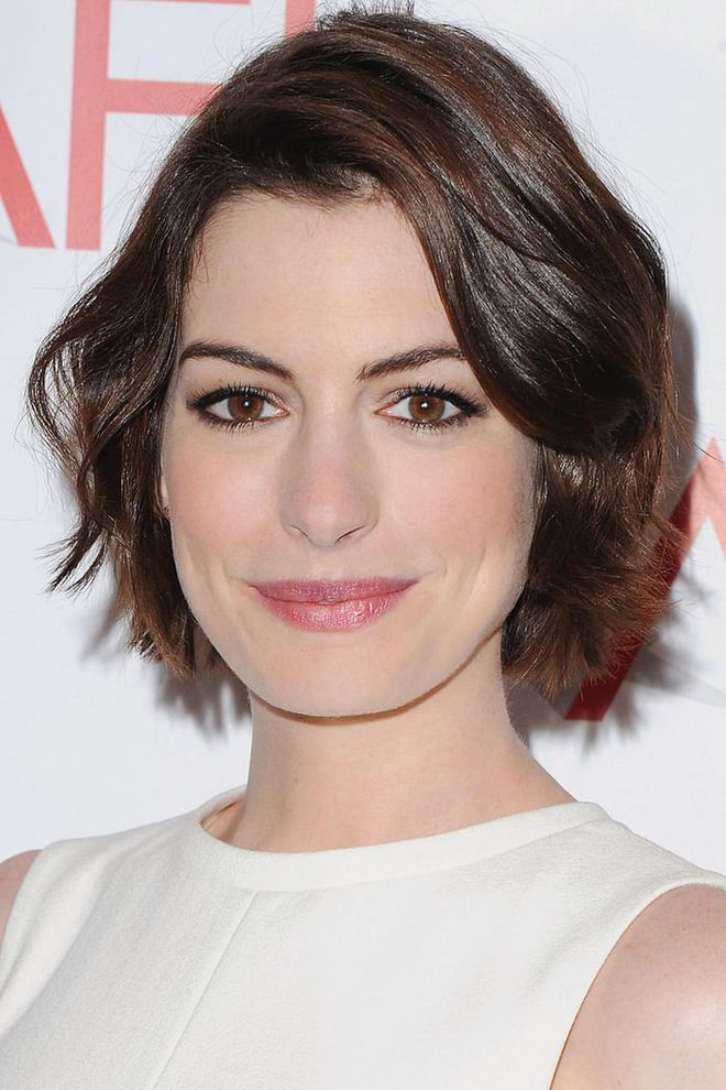 Anne Hathaway adds soft waves and a deep part to add femininity to a grown-out pixie.