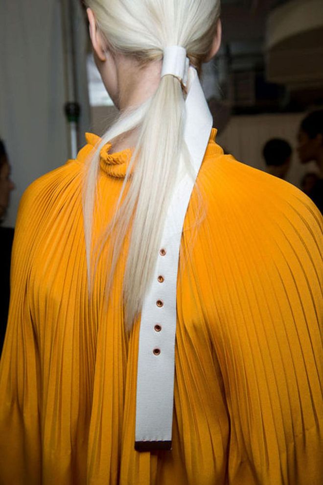 The Look: Belted Hair 
How-To: We thought we'd seen it all when it comes to runway hair accessories. But Tibi's spring 2017 show managed to deliver both shock and delight: belts (yes, belts) were used to wrap and decorate the sleek ponytails seen backstage. And it looked damn adorable. Hairstylist Frank Rizzieri secured models' hair into sleek, low ponytails, then slipped on the custom made belt accessories much like you would a grosgrain ribbon. The end of each belt hung parallel to the ponytail. If nothing else, this look has inspired us to give new life to the collection of d-ring belts we've long since forgotten about. Photo: IMAXTREE