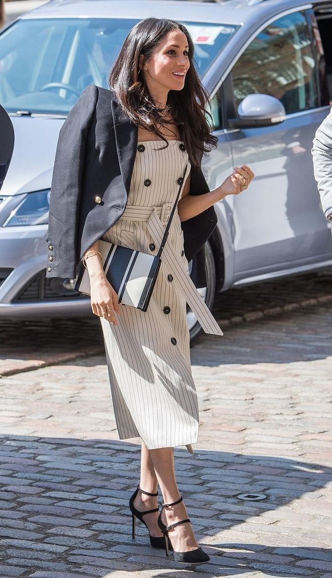 Meghan was at the reception of the Commonwealth Youth Forum wearing a chic pinstriped Altuzarra trench dress with a black Camilla & Marc blazer draped on her shoulders. The royal-to-be accessorised with strappy suede heels by Tamara Mellon and a stripped Oroton bag. 