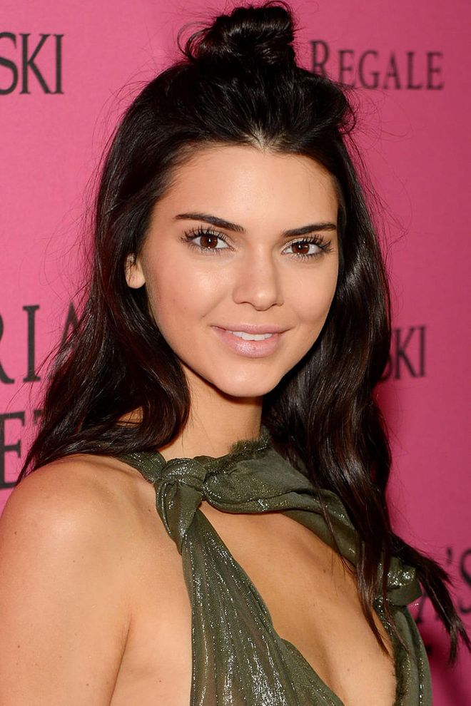 Kendall Jenner's loose waves offset her mussed-up top knot. Photo: Getty