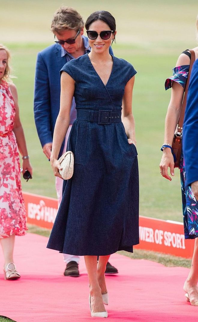 Meghan showed us exactly how a royal would do denim with this belted navy blue Carolina Herrera dress, and paired it with Tom Ford statement sunglasses, Aquazzura nude pumps, and an affordable rattan clutch from J.Crew. Photo: Getty 